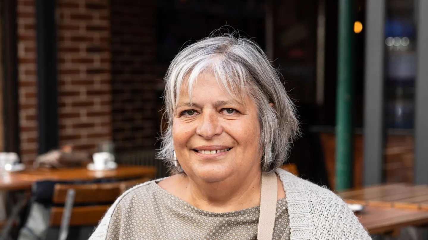 Sandrine Oberbek assise avec des tables de restaurant derrière elle