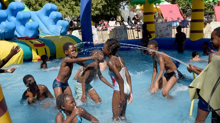 Groupe d'enfants du quartier de La Noue jouant dans une piscine gonflable