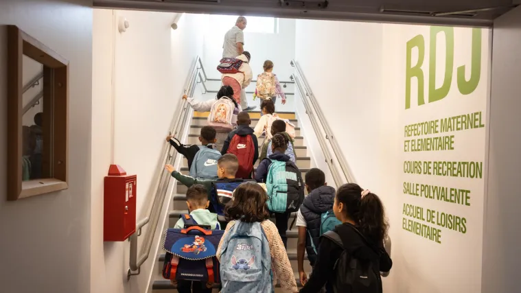 Un groupe d'enfants montant les escaliers dans l'école du groupe méliès