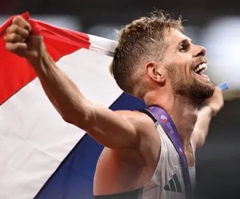 Jimmy Gressier souriant et tenant un drapeau français