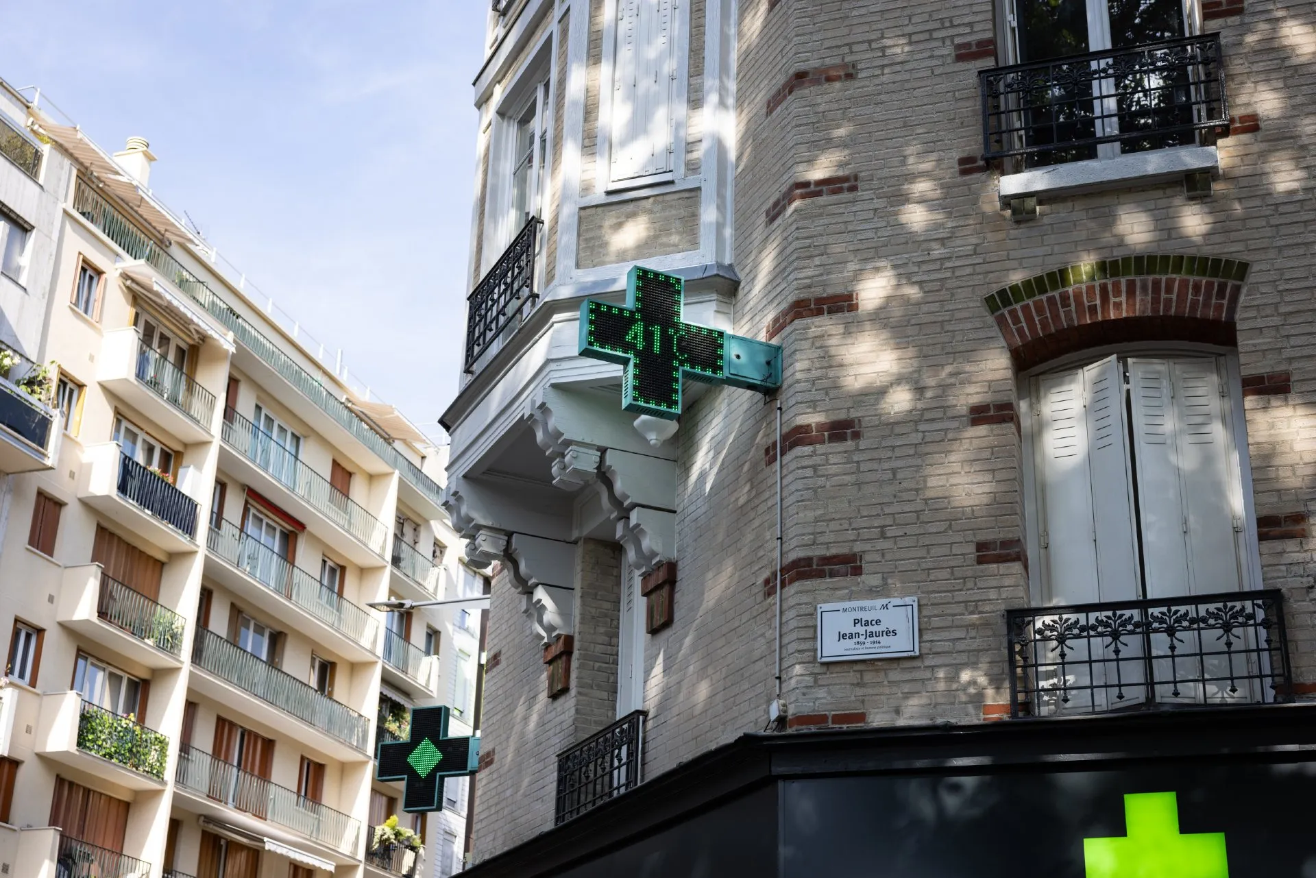 Croix verte d'une pharmacie se trouvant sur la façade d'un immeuble